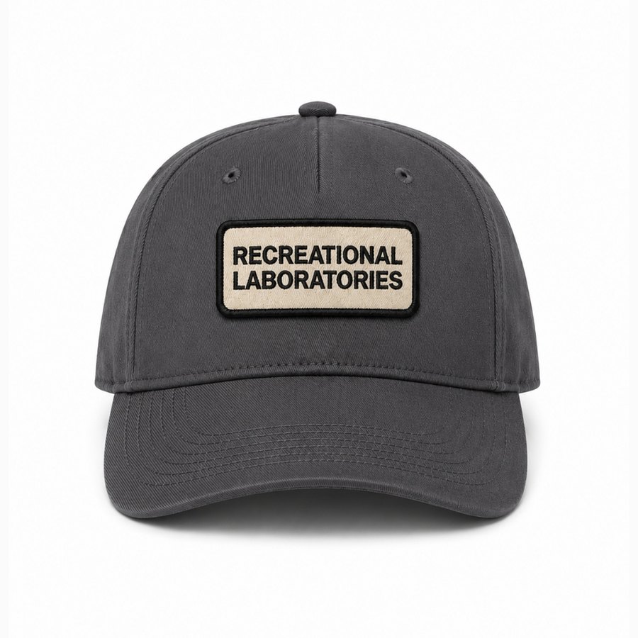 Embroidered oval patch on cream cap with black brim